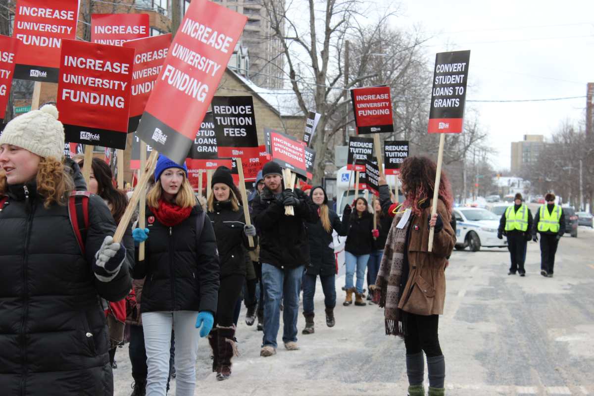 Students raise signs in hopes of lower fees